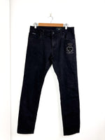 Load image into Gallery viewer, Black jeans with a heart design on a hanger against a white background
